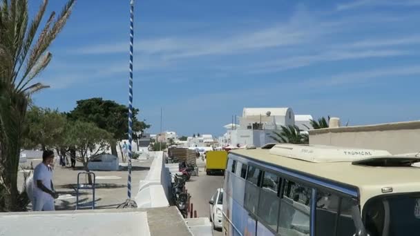 イア、サントリーニ島 (ギリシャ) の町の街並み。小さな道路渡しバス。交通渋滞. — ストック動画