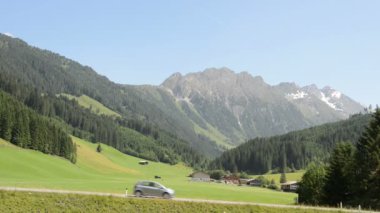 Schoenachtal (Schoenach Valley) adlı bir sokakta araba geçip. Hohe Tauern arka planda dağlar. Gerlos 16 Temmuz 2013 üzerinde bulunan