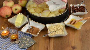 Elmalı pasta pişirme. Ham elma pasta üzerine serpilir tarçın. Ayrıca, bal, tarçın, badem slivers gibi maddeler vardır