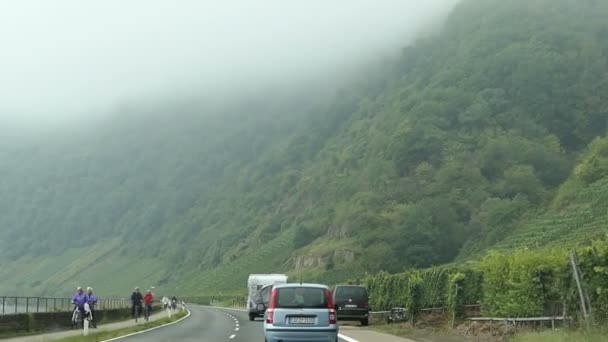 Körning med en bil längs regionen mosel floden bredvid Bremm (Tyskland). fält och byn i bakgrunden. Landscape.Tractor framför. — Stockvideo