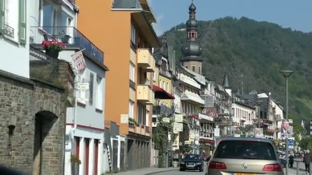 Autos fahren durch die Moselstadt Cochem. Menschen, die an traditionellen Häusern entlang gehen. Stadtbild. — Stockvideo