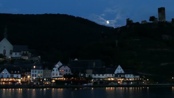 Stadtbild von Beilstein in der Dämmerung bei Mondschein. Autos fahren vorbei. Mosel fließt vor. — Stockvideo