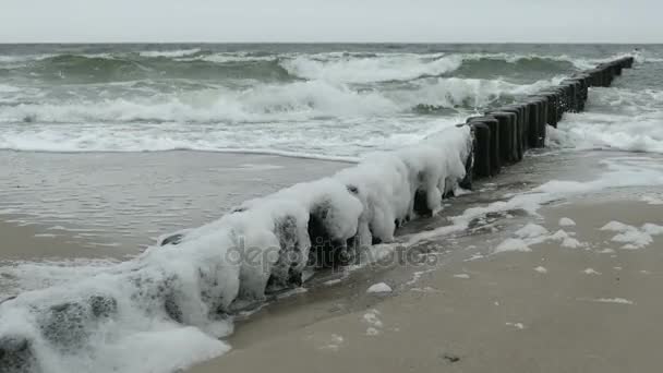 Stormachtig weer op strand van de Oostzee. golven op de groynes en bubbels. — Stockvideo