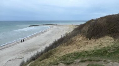 Ahrenshoop Baltık Denizi 'nin sahil uçurumundan sahile kadar havadan izleniyor. Yürüyen insanlar.