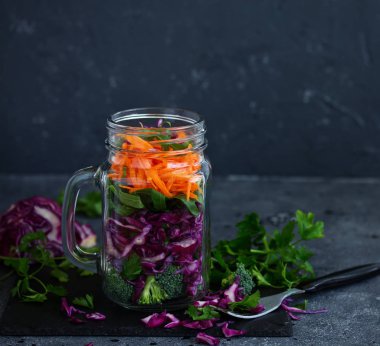 Salata, kırmızı lahana, havuç ve yeşillik bir kavanoza. sağlıklı beslenme. Seçici odak.