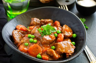 Burgundy 'de sığır güveci. Şarabın içinde havuç, soğan, bezelye ve şampiyonlarla. Yukarıdan görüntüle.