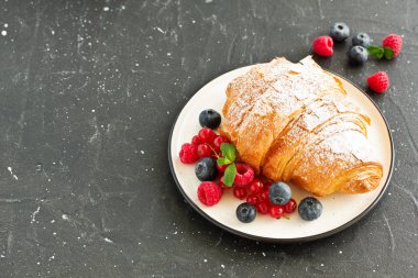 Lezzetli kahvaltı taze kruvasanlar ve olgun çilek ile
