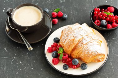 Lezzetli kahvaltı taze kruvasanlar ve olgun çilek ile