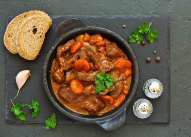 Beef stew in Burgundy. With carrots, onions, peas and champignons in wine. View from above. clipart