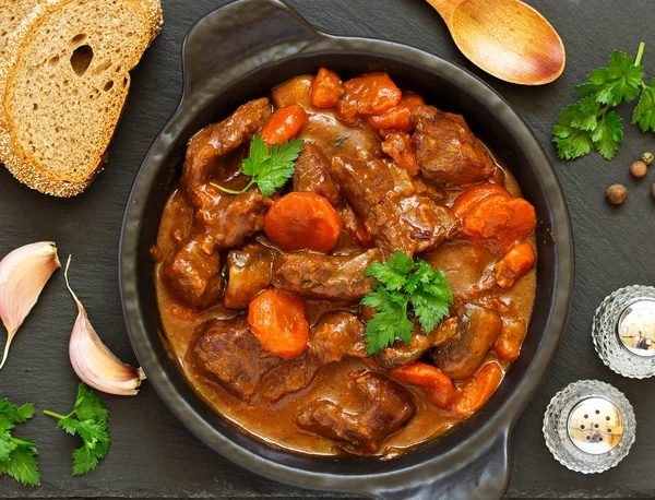 Burgundy 'de sığır güveci. Şarabın içinde havuç, soğan, bezelye ve şampiyonlarla. Yukarıdan görüntüle.
