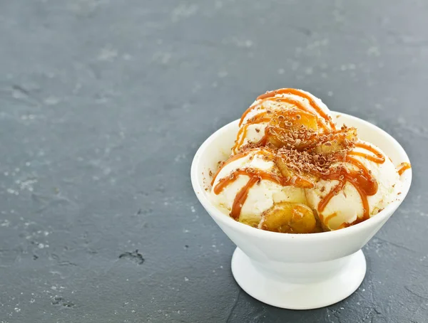 vanilla ice cream with bananas and caramel in a bowl.