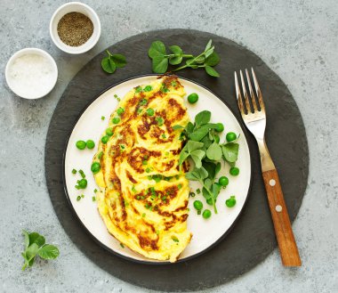 Kahvaltıda. İtalyan omleti, yeşil bezelye ve salata..