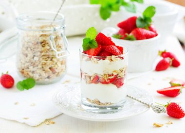 Granola, yoğurt ve çilekli bir bardakta tatlı. Yararlı bir kahvaltı..
