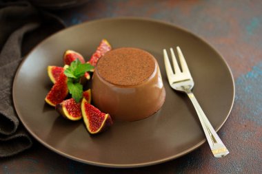 Ev yapımı lezzetli çikolata tatlı Panna cotta. Krem karamel, karamelli muhallebi, incir ile.