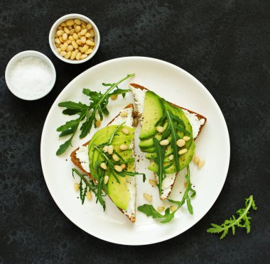 Avokado, keçi peynir ve roka ile sandviç. Yukarıdan görüntülemek.