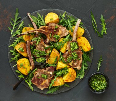 Pirzola kuzu kemik, fırında patates ve pesto sos ile.