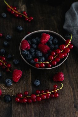 Olgun taze yaban mersini, ahududu ve ahşap kırda kırmızı frenk üzümü.