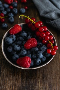 Olgun taze yaban mersini, ahududu ve ahşap kırda kırmızı frenk üzümü.