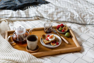Yatakta kahvaltı, hamur işi, taze meyve, siyah çay.