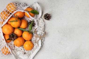 Eko noel konsepti, pamuk örgüsü içinde organik olgun mandalinalar.