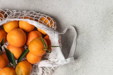 Eko noel konsepti, pamuk örgüsü içinde organik olgun mandalinalar.