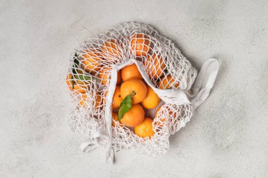 Eko noel konsepti, pamuk örgüsü içinde organik olgun mandalinalar.