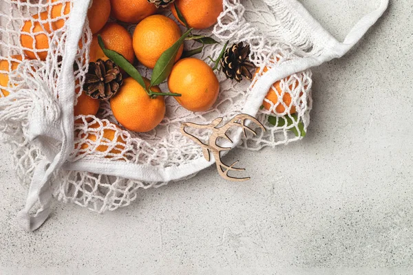 Eco christmas concept, organic ripe clementines in cotton mesh b — Stock Photo, Image