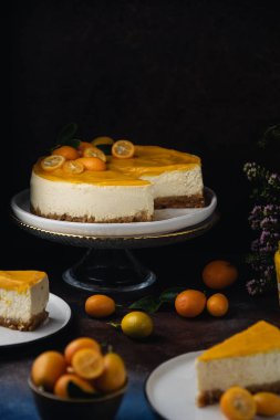 Koyu kırsal arka planda kumkatlı Citrus peynirli kek.