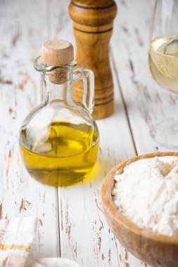 Pastane ya da ev yapımı ekmek ya da makarna, zeytin yağı, un, beyaz ahşap masa üzerinde beyaz şarap.