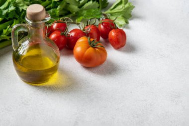 Akdeniz mutfağı, taze olgun domatesler, zeytinyağı, gri arka planda kereviz, kopyalama alanı