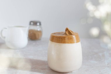 Moda Kore buzlu dalgona kahvesi, pembe mermer masada çırpılmış kahve.