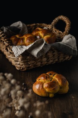 Çikolata parçacıklı taze brioche, bal, tereyağı, siyah ahşap arka planda süt.