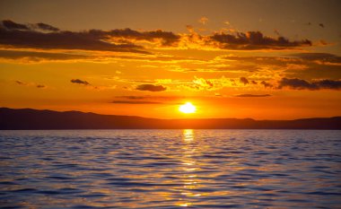Denizin üzerinde çarpıcı günbatımı