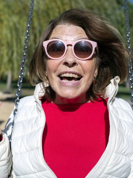 Cool older woman on a swing — Stock Photo, Image