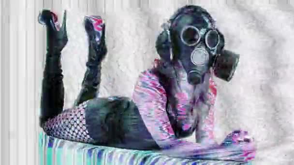 オーバーレイグリッチと歪み効果を持つソファに横たわるガスマスクの若い女性 — ストック動画