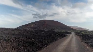 Kamera bir off-road aracının önüne bağlı ve dağ manzaralı yoldan geçiyor.