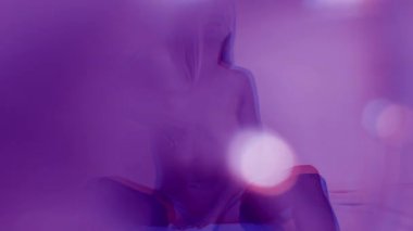 Çekici, çıplak bir genç kadın poz veriyor ve hareket ediyor.