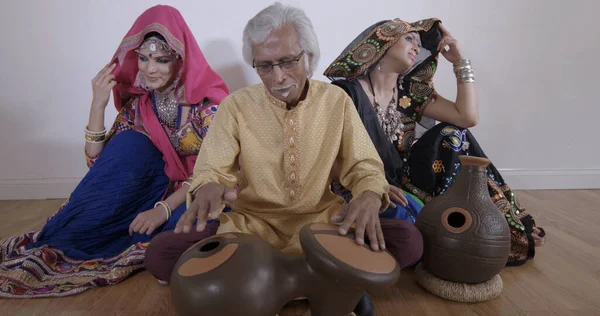 Hombre tocando la batería india con bailarinas . —  Fotos de Stock