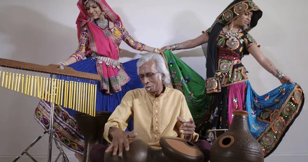 Hombre tocando la batería india con bailarinas . —  Fotos de Stock