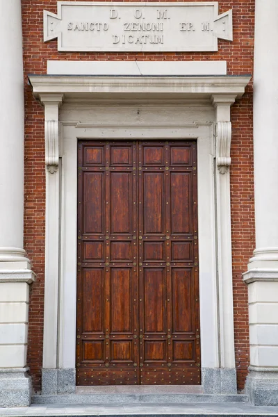 Mosazi hnědou klepadlo a dřevěné dveře kostela Crema — Stock fotografie