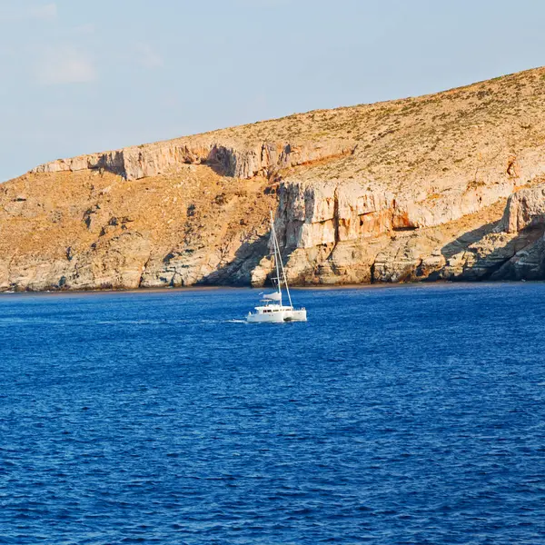 Vela vicino alla collina e rocce sulla spiaggia estiva in Europa g — Foto Stock