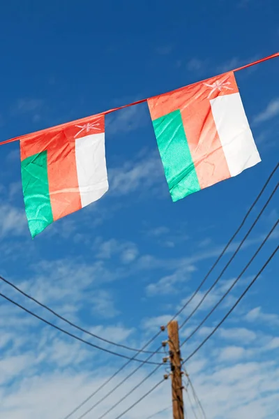 I oman viftande flagga och molnigt himlen — Stockfoto