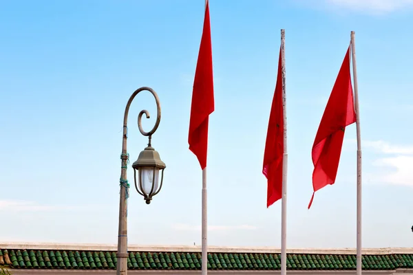 Tunisia acenando bandeira na cor do céu azul e lâmpada de rua — Fotografia de Stock