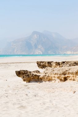 Umman Arapça deniz kumlu plaj gökyüzü ve dağ yakınlarındaki tepe