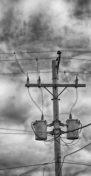 Un poste eléctrico con transformador y alambre el cielo nublado — Foto de Stock