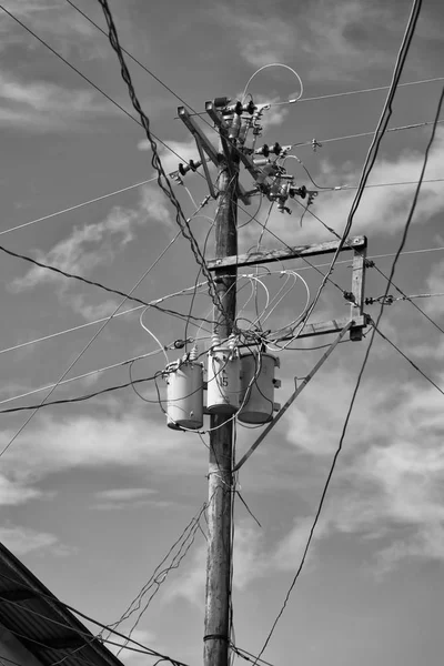 Un poteau électrique avec transformateur et fil le ciel nuageux — Photo