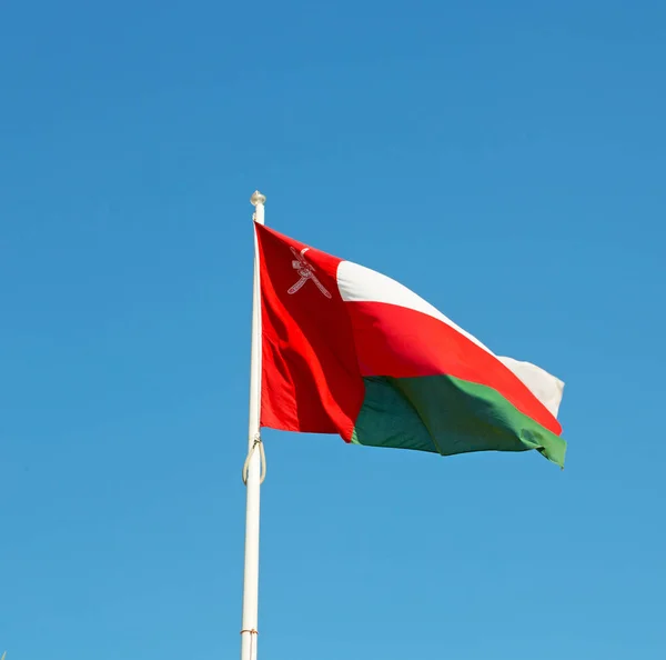 Em oman acenando bandeira e o céu nublado — Fotografia de Stock