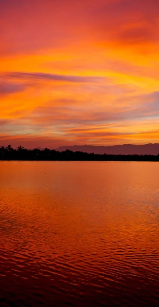 Vista desde el agua del amanecer llena de colores — Foto de Stock