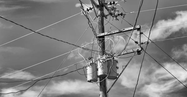 Ein Strommast mit Transformator und Draht in den bewölkten Himmel — Stockfoto