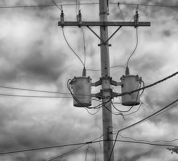 Un poste eléctrico con transformador y alambre el cielo nublado — Foto de Stock